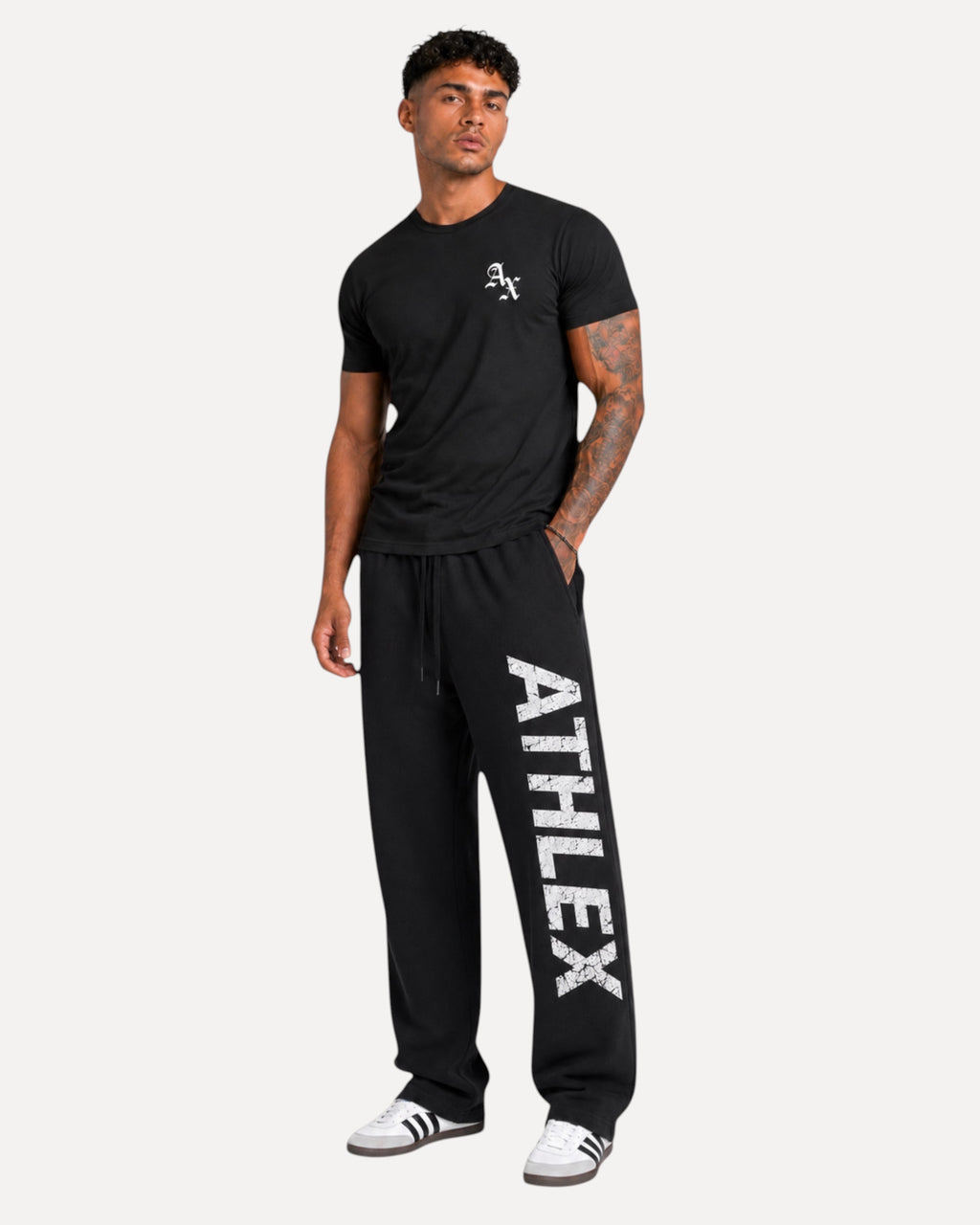 My Store Athlex AX black cotton t-shirt with white logo worn by a model with joggers and sneakers