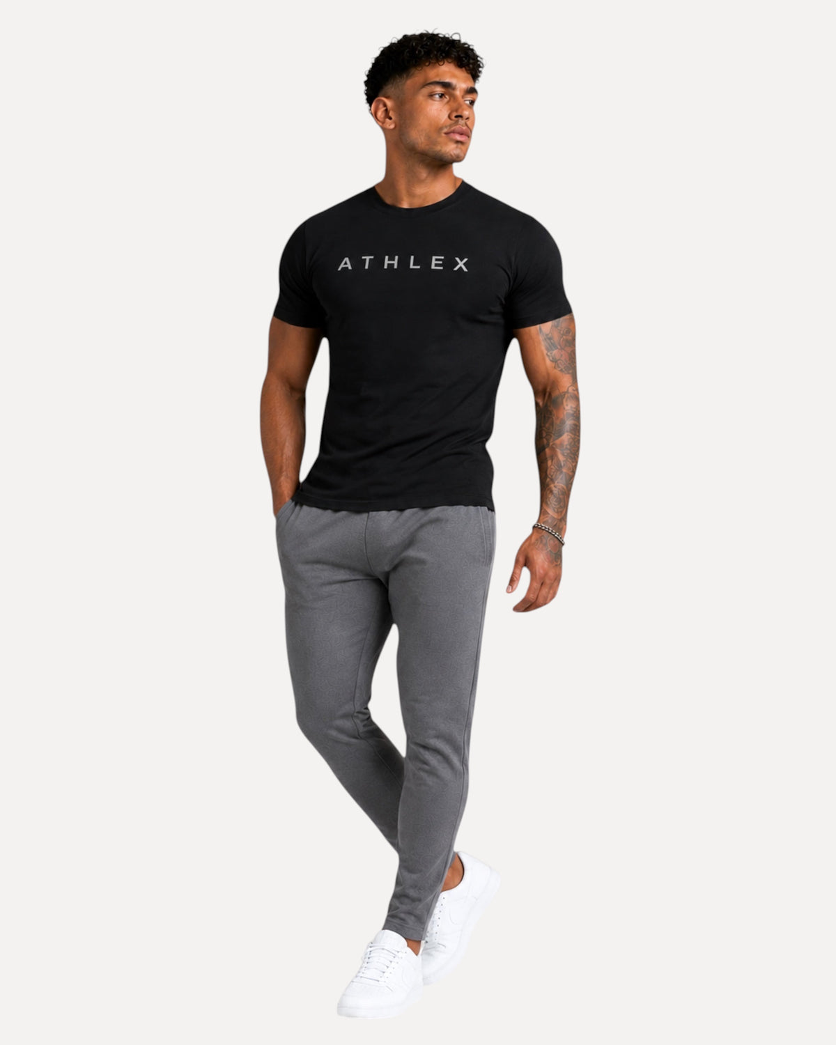 My Store ATHLEX ShadowFlex black cotton tee worn by a fit model with grey joggers and white sneakers.