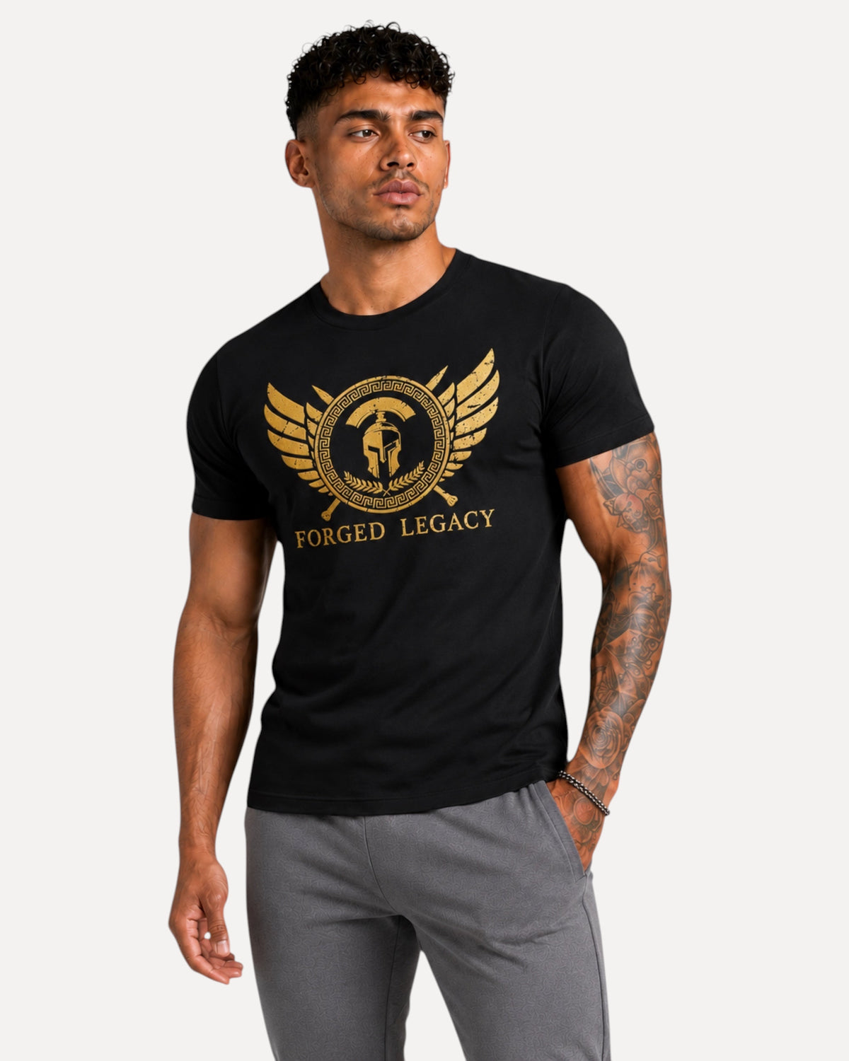 My Store ATHLEX Forged Legacy black cotton t-shirt with gold warrior helmet graphic worn by a tattooed man