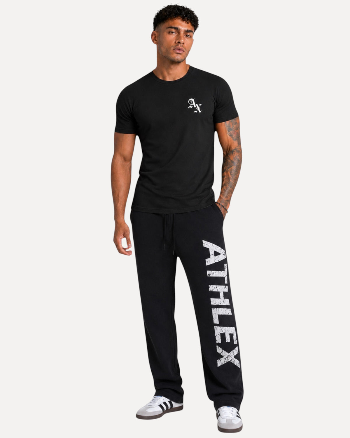 My Store Athlex AX black cotton t-shirt with white logo worn by a model with joggers and sneakers