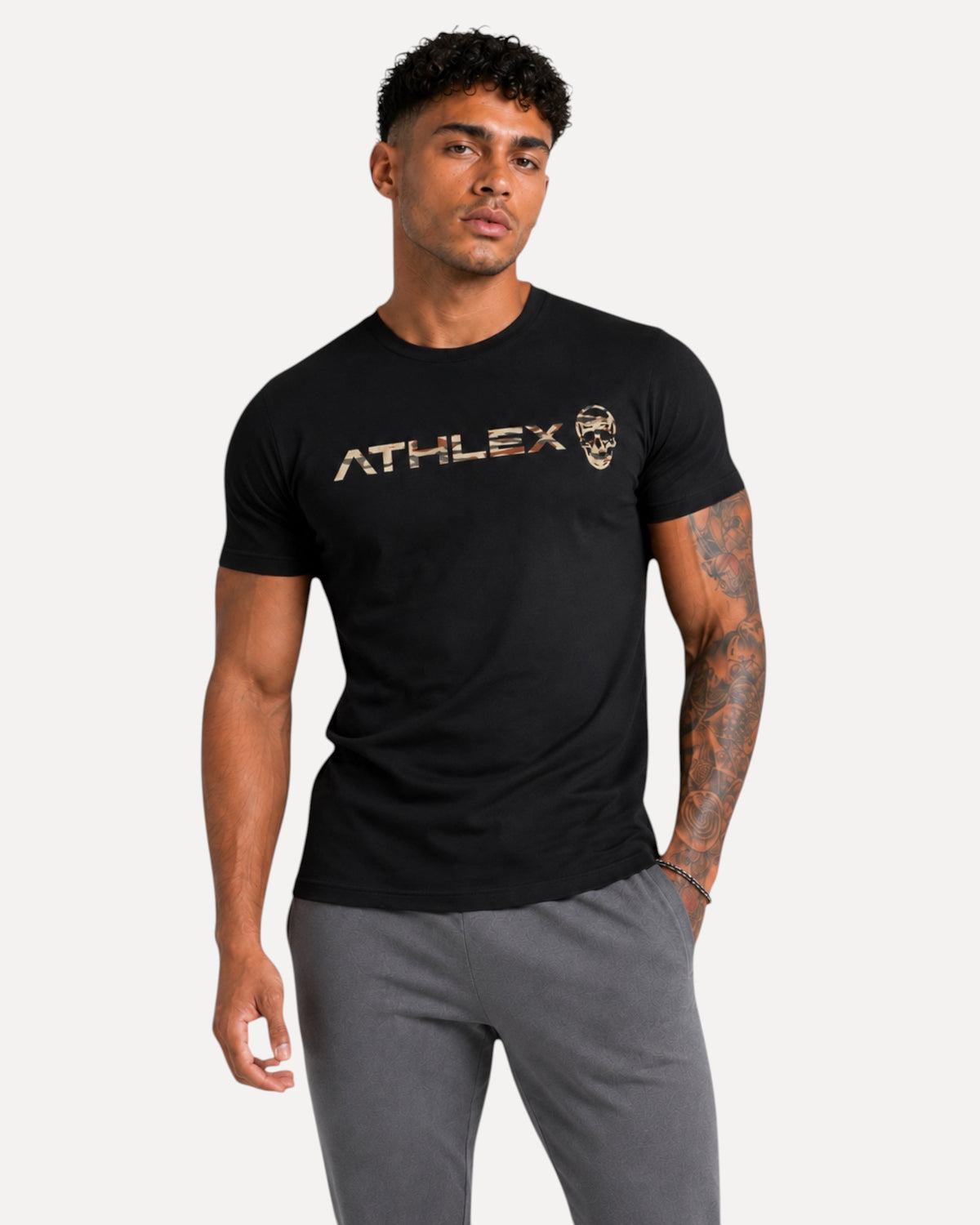My Store ATHLEX black cotton crew neck tee with camo skull logo worn by a fit man in grey joggers