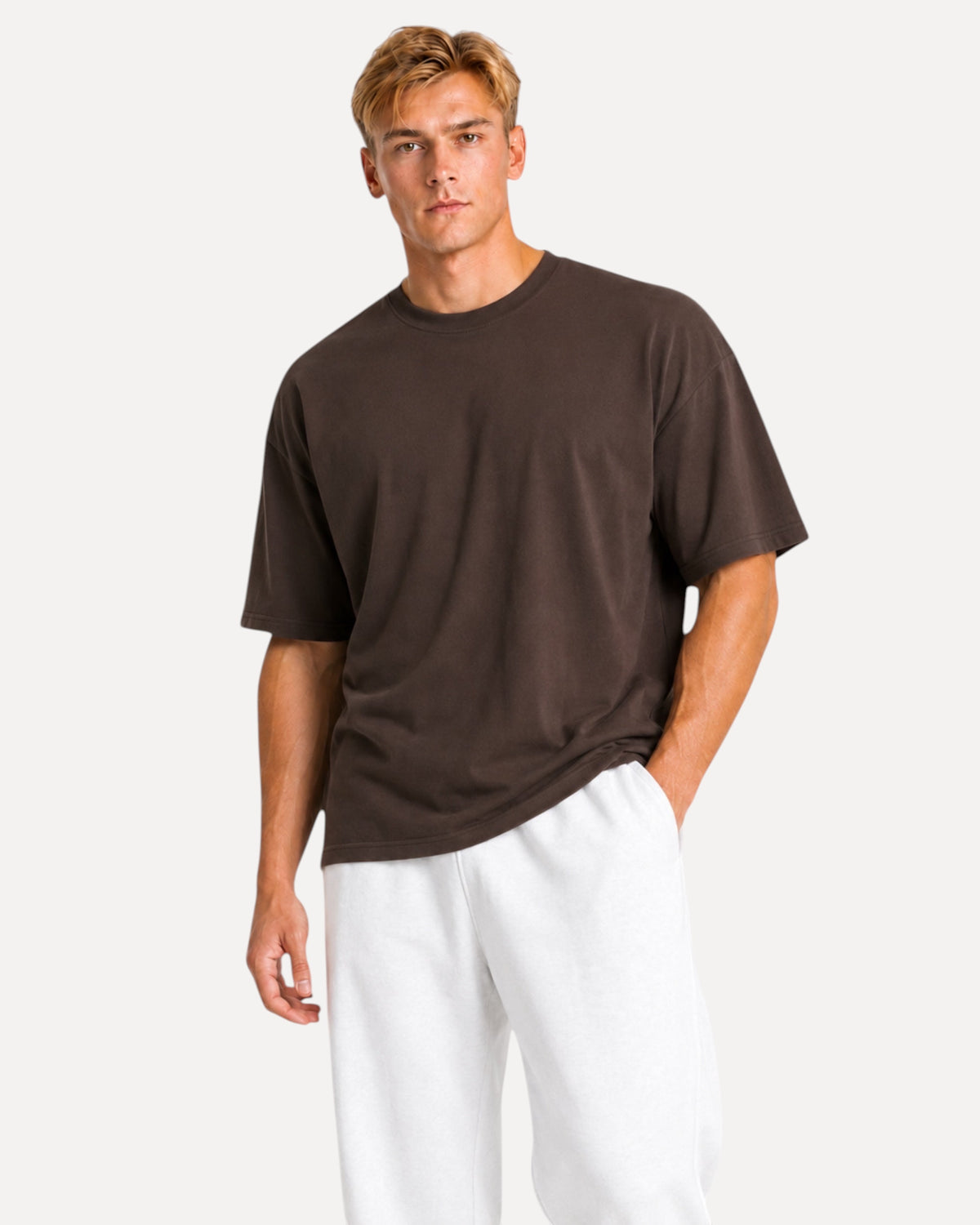 My Store Athlex oversized chocolate brown t-shirt worn by a man with white joggers for a relaxed streetwear look.