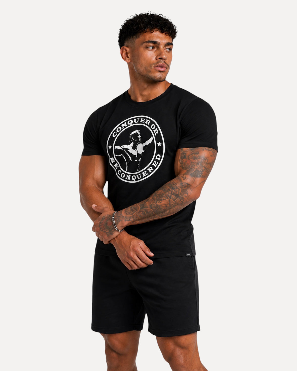 My Store ATHLEX Conquer black graphic t-shirt with white circular chest print worn by a muscular man