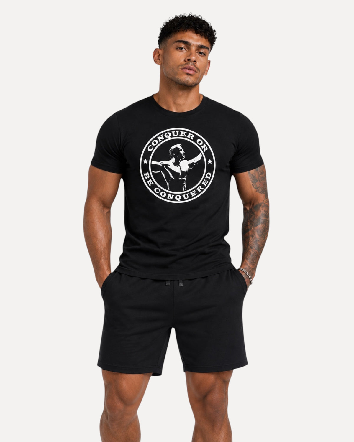 My Store ATHLEX Conquer black graphic t-shirt with white circular print worn by a muscular man in gym shorts