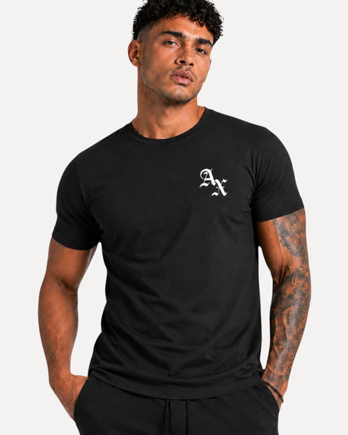 My Store Athlex AX black cotton t-shirt with white logo on chest worn by a fit model with tattoos
